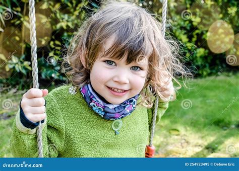 Beautiful Little Girl Playing On Her Swing In The Garden Stock Image