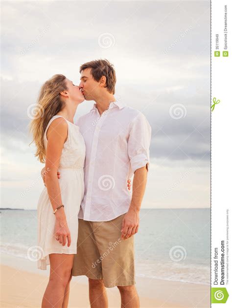 Happy Romantic Couple Kissing On The Beach At Sunset Stock Image