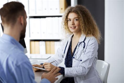 Female Doctor And Male Patient Discussing Current Health Examination