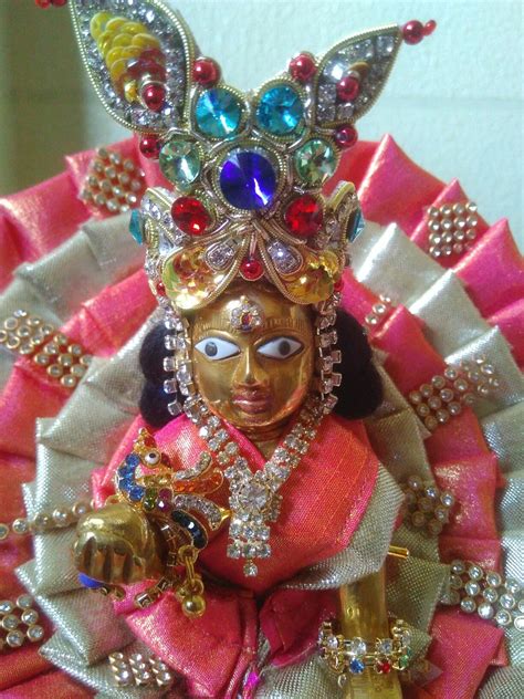 a close up of a statue on a pink and white cloth with jewels around it