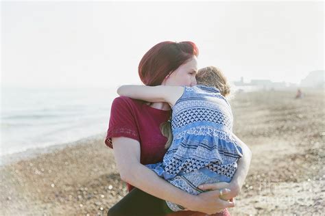 Mother Holding Daughter On Beach Photograph By Caia Imagescience Photo