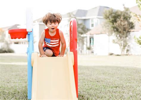 Closeup Of A Little Boy Playing In The Playground On Slides Stock Photo