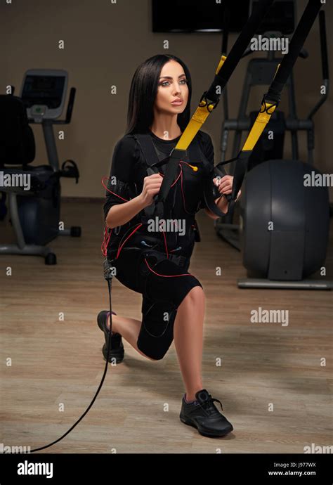 Brunette Girl In Electrical Muscular Stimulation Suit Doing Squat