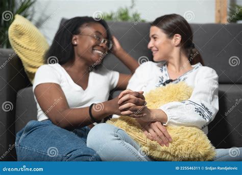 joven y hermosa mezcla de raza lesbiana pareja de afroafricanas negras y caucásicas sentadas en