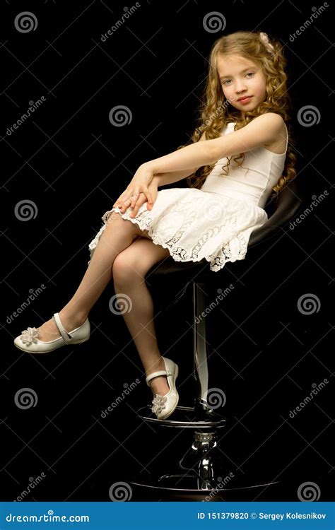 Kleines M Dchen Sitzt Auf Einem Stuhl Stockfoto Bild Von Entz Ckend