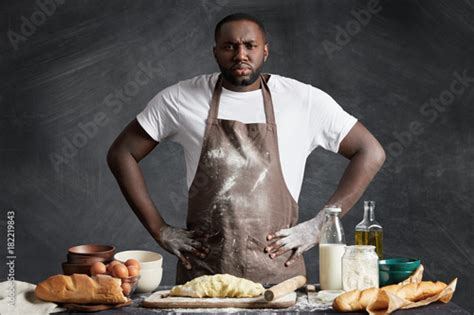 Confident Serious Dark Skinned Male Chef Wears Apron Keeps Hands On