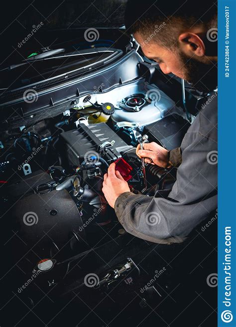 Focused Mechanic Doing Car Repair Disconnecting The Battery Terminal