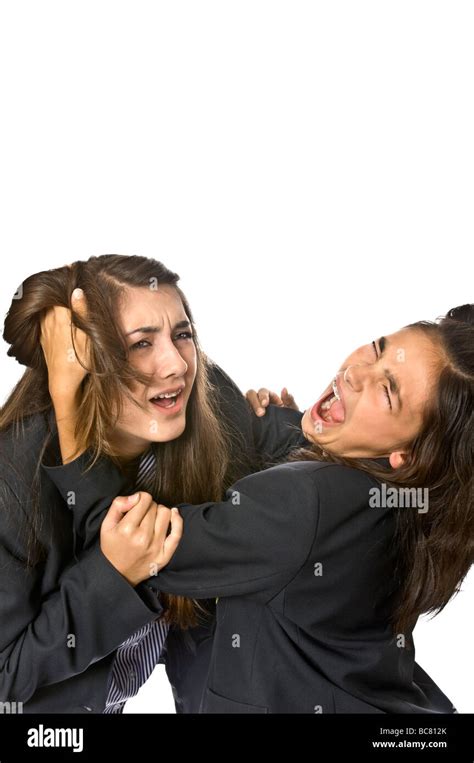Vertical Close Up Portrait Of Angry Teenage School Girls Pulling Each