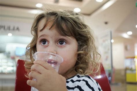 Adorable Little Girl Drinks Water From A Bottle Stock Photo Image Of