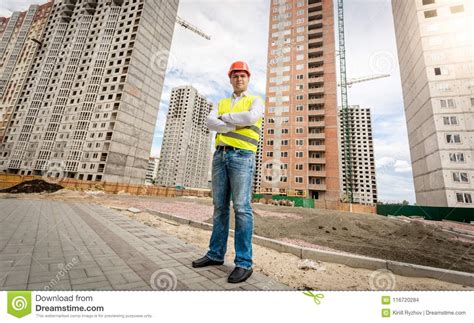 Male Construction Engineer In Hardhat Standing On Building Site Stock