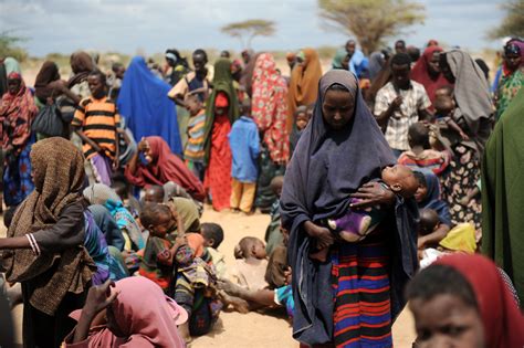 Somali Refugees Crowd A Fence Enclosing A Food Distribution Point At