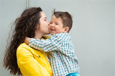Joven Madre Besando A Su Bebé Foto Premium