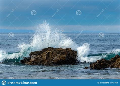 Wave Breaking On Rock Near Shore White Spray In The Air Ocean Blue