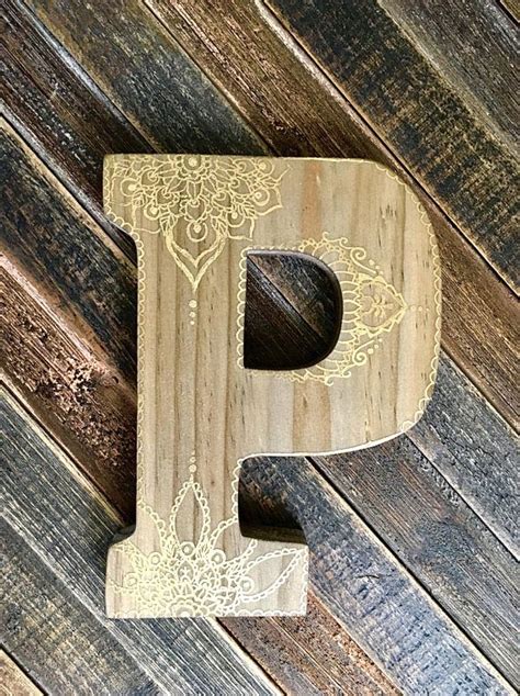 This Wooden Letter Has A Light Stain And Is Hand Decorated With White