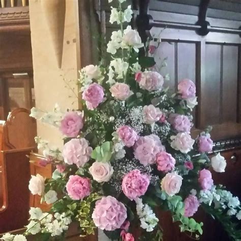 A Vase Filled With Pink And White Flowers Sitting On Top Of A Wooden