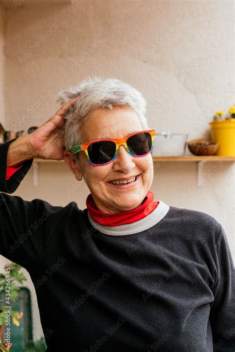 Foto Stock Vertical Portrait Of Older Lesbian Woman With Short Gray Hair Wearing Rainbow Pride