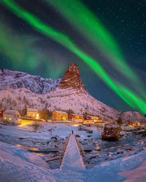 Breathtaking Aurora Borealis Above A Fishing Village In Lofoten Islands