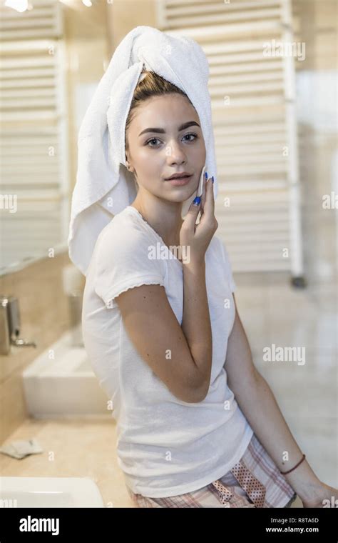 Attractive Young Woman In Bathroom After Shower Is Standing In Front Of