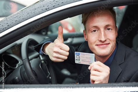 Young Man Holding Drivers Licence And Thumps Up Imagens E Fotos De