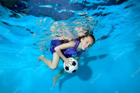 Niña Feliz Nadando Y Jugando Bajo El Agua Con Una Pelota De Fútbol