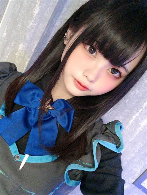 a woman with long black hair wearing a blue and black outfit posing for the camera