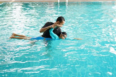 Padre Enseñando A Su Hija A Nadar En Una Piscina Foto Premium