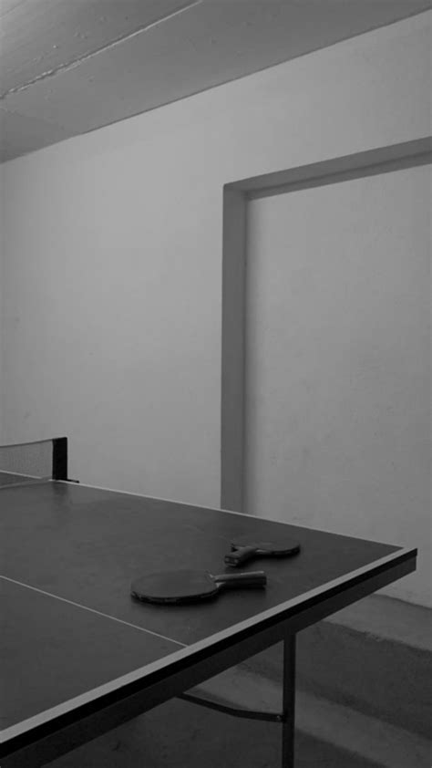 A Ping Pong Table With A Pair Of Scissors On It In An Empty Room