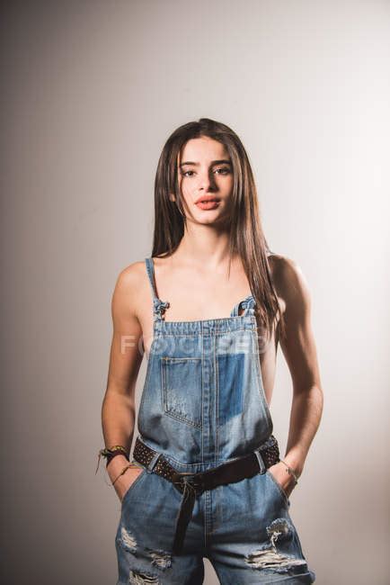 Brunette Topless Girl Posing In Denim Overall And Looking At Camera Person Femininity Stock
