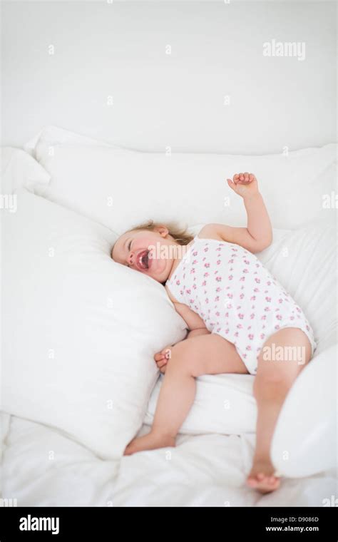Kleines Mädchen Auf Dem Bett Liegend Und Lachen Stockfotografie Alamy