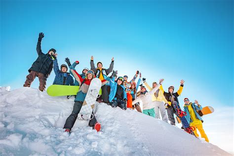 Big Group Of Happy Skiers And Snowboarders With Raised Arms Stan