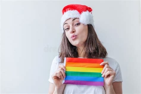 Красивая лесбиянка в красной шляпе Санта Клауса с символом ЛГБТ изолированной на белом фоне