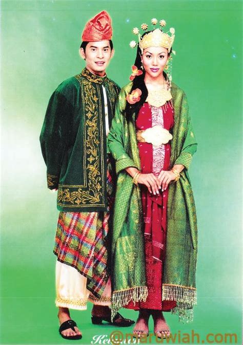 Two People Are Dressed In Traditional Clothing And Posing For A Photo Together On A Green Background