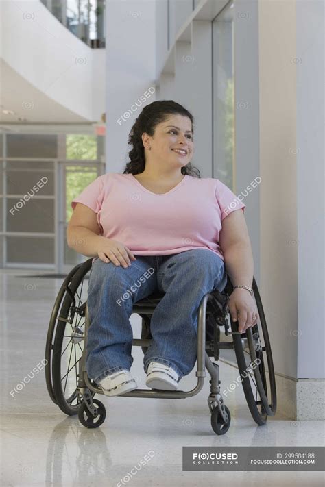Mujer Con Espina Bifida Sentada En Silla De Ruedas Y Sonriendo