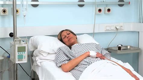 Woman Lying On A Medical Bed While Closing Her Eyes In Hospital Ward