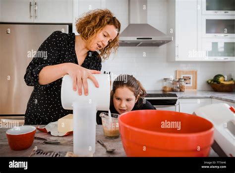 Mother Teaching Daughter To Cook In Kitchen At Home Stock Photo Alamy