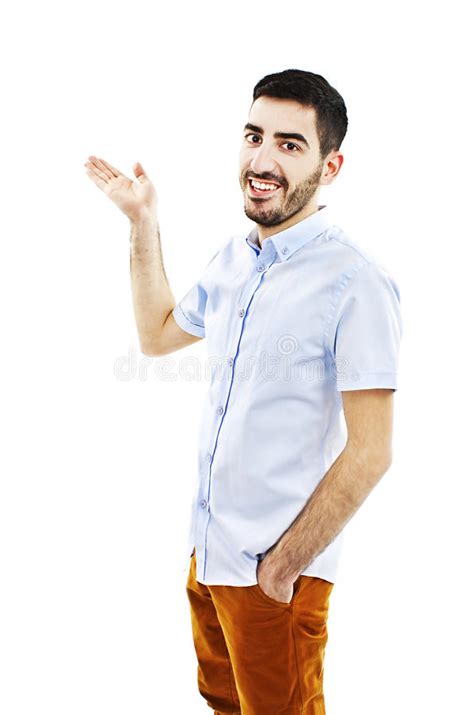 Friendly Young Man Pointing To His Side And Looking Into The Camera