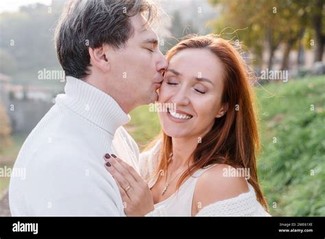 A Loving Couple Husband And Wife Hugging A Man Gently Kisses A Woman On The Cheek She Smiles