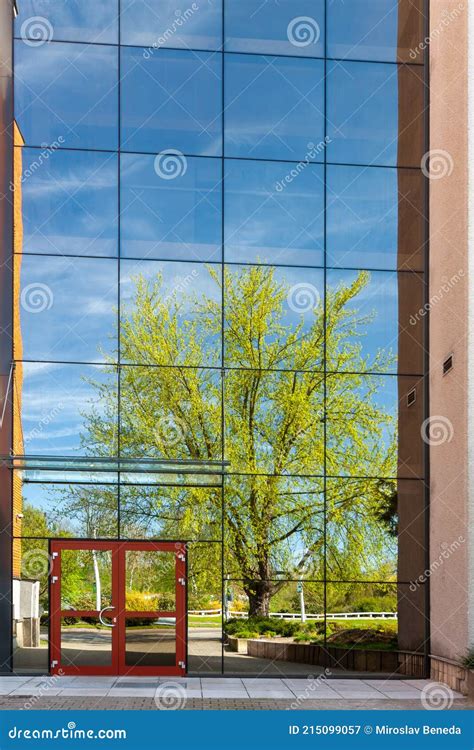 A Modern Office Building With Glass Doors And Windows Reflection In