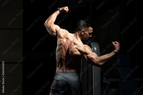 Muscular Man Flexing Muscles Rear Double Biceps Pose Stock Photo