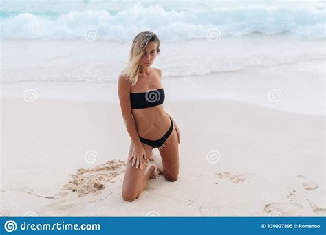 Sexy Gelooid Model In Het Zwarte Swimwear Stellen Op Wit Zandig Strand Stock Afbeelding Image