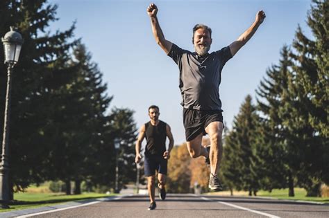 The Two Men Running On The Road In The Park Stock Image Everypixel