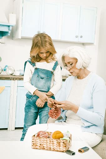Grandmother Shows Her Granddaughter How To Knit Stock Photo Download