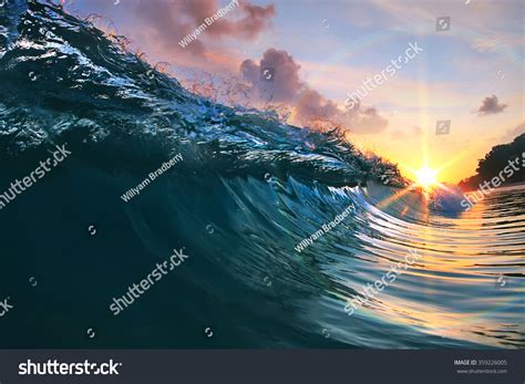 Beautiful Blue Ocean Surfing Wave Under Sunset Stock Photo