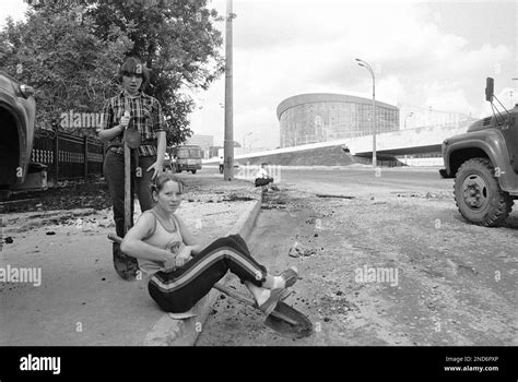 Soviet Girl Workers Rest On The Pavement Outside An Olympic Venue Hall Next To The Main Stadium