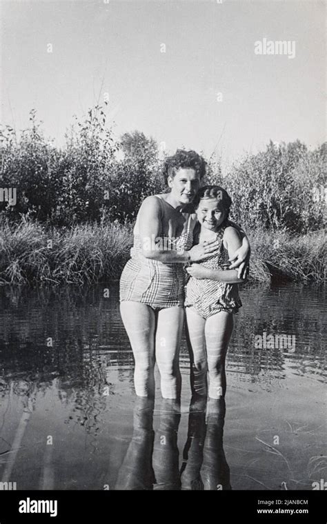 Vintage Photo Of A Mother And Daughter Wearing Bathing Suits Standing In A Reflective Pond 1958