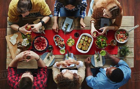 High Angle View Of Babe People Sitting At Table And Having Dinner Stock Photo Dissolve