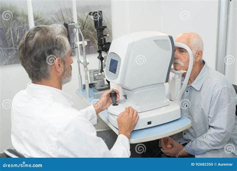 Male Optometrist Doing Sight Testing For Old Patient Stock Photo