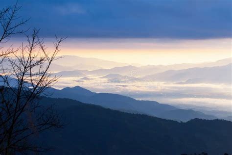 Serene Scenery Of Blue Mountain Range In The Morning Mist A Village