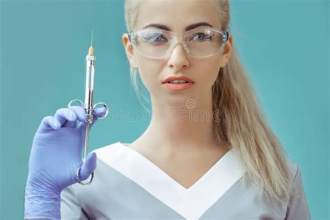 Dentist Holding A Syringe Scared Patient Are In The Background Stock