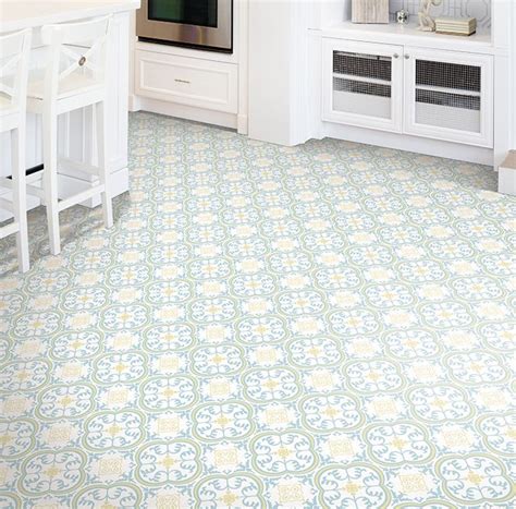 A Kitchen With White Cabinets And An Ornate Tile Flooring Pattern On